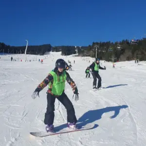 Uczestnicy obozu snowboardowego w kamizelkach R&oacute;ży Wiatr&oacute;w na słowackim stoku
